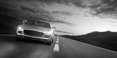 Sports car driving on an empty road.