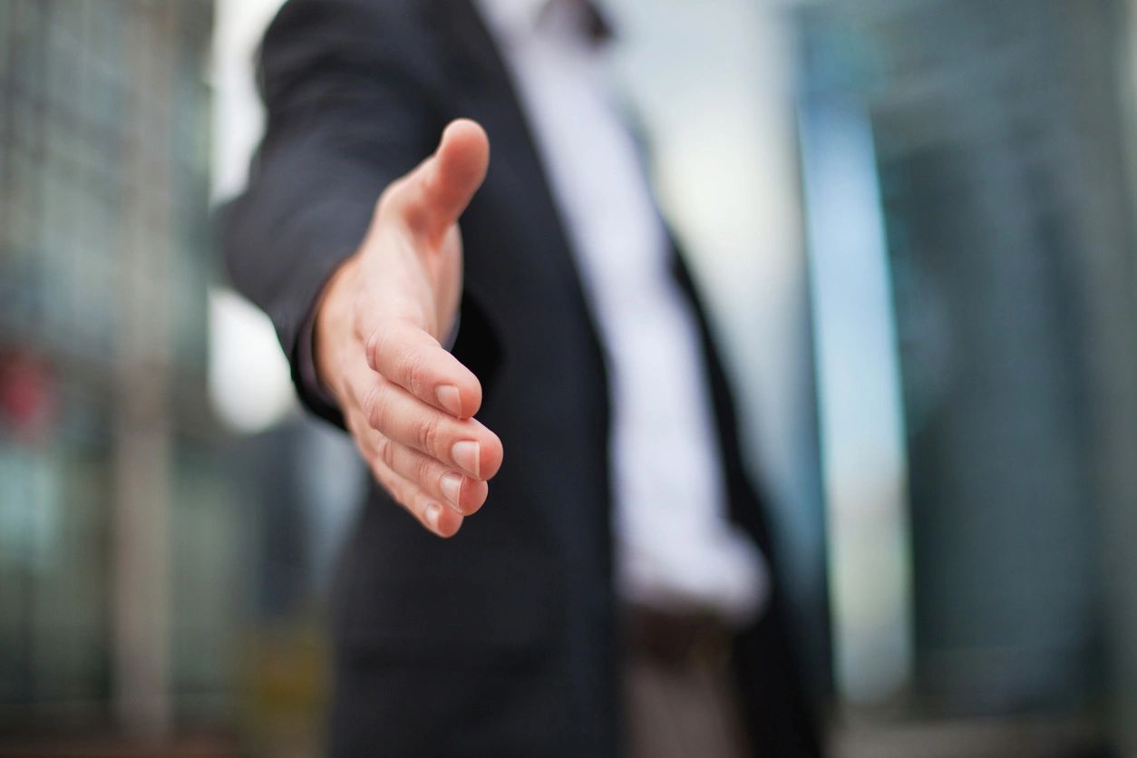 Businessman reaching out to shake hands