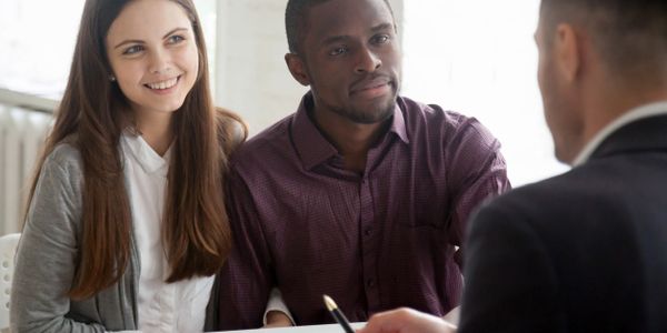 a person is discussing documents with a couple