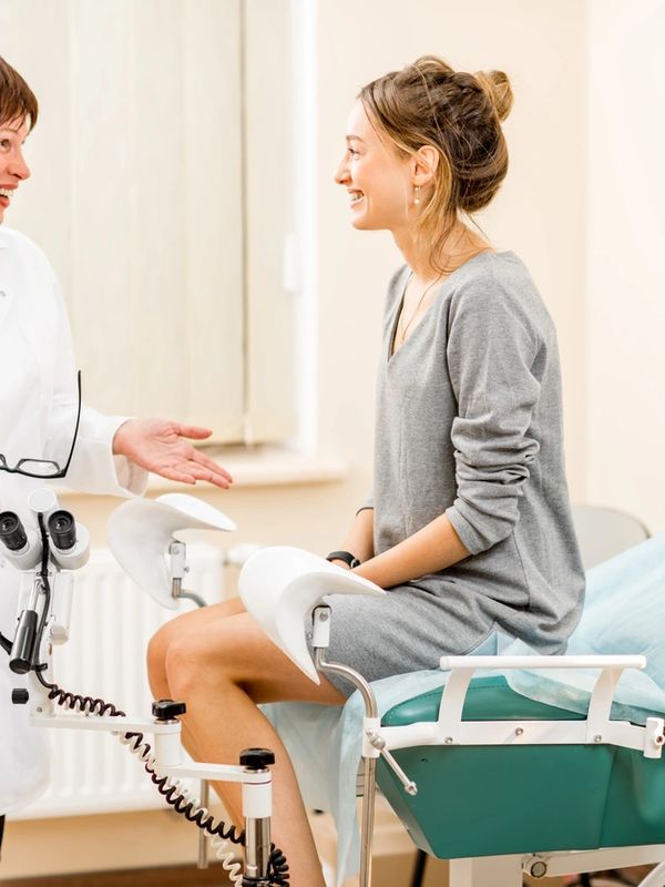 A woman consults with a gynecologist in a clinic room.