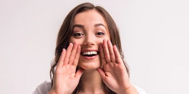 A woman shouting about news and offers at Moray Massage Therapy. 