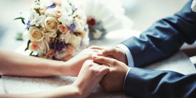 Picture of groom's hands holding bride's hands.