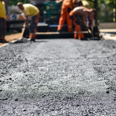 Workers paving with asphalt