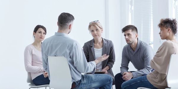 A group in a serious discussion in a bright room.