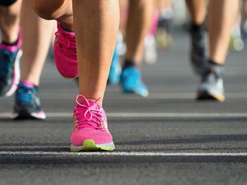 Close-up of runners' feet in colorful sneakers during a race.