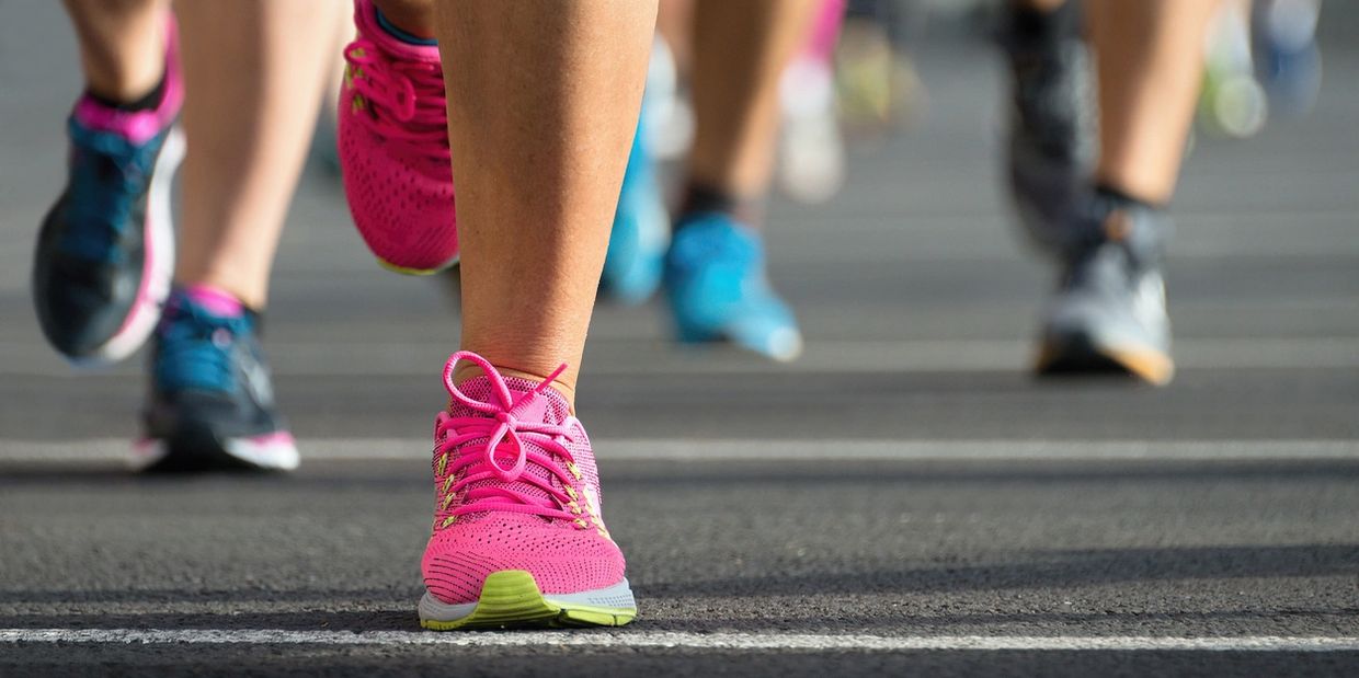 Close-up of runners' colorful shoes during a race start.