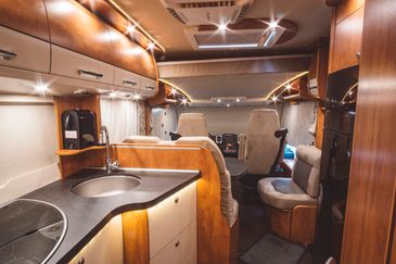 Cozy and modern RV interior with kitchen and seating area.