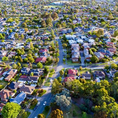 Aerial view of a suburban neighborhood with houses, trees, and roads.