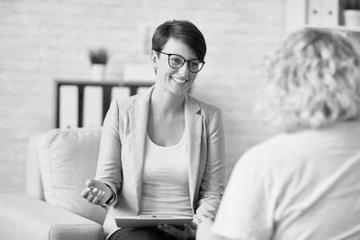 A woman therapist listens and smiles during a session with a client.