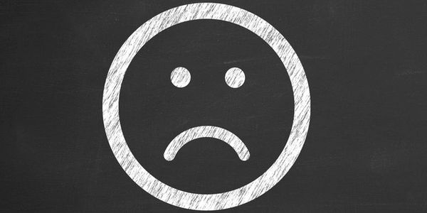White chalk smiley face drawn on blackboard.