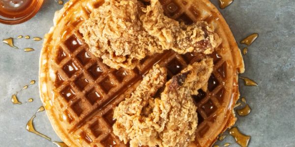 Fried chicken pieces on a waffle with syrup.