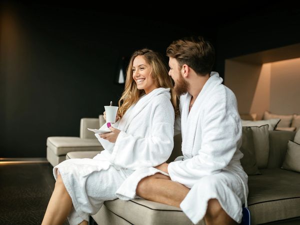 Couple relaxing in a vacation rental bedroom with fresh bedding
