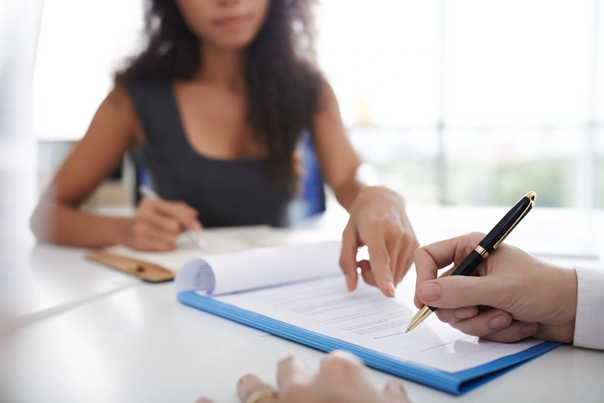 Two people involved in filling out a document on a clipboard.