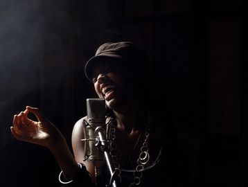 artist singing into a microphone