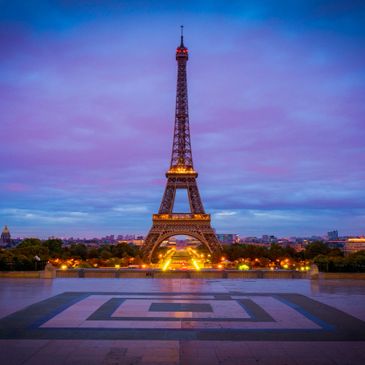 Eiffel Tower illuminated at twilight in Paris.