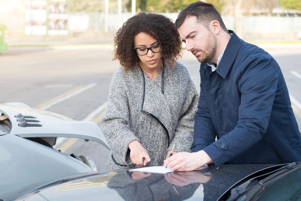 Two People Sharing insurance information after an unfortunate accident.