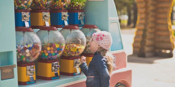 Girl using gumball machines