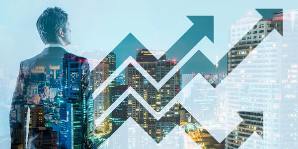upward zigzag arrows in front of a skyline backdrop with silhouette of man