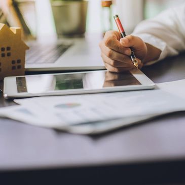 SEO Expert's hand holding a pen, analyzing SEO Data on a Tablet - Charles Kendall's Marketing Agency