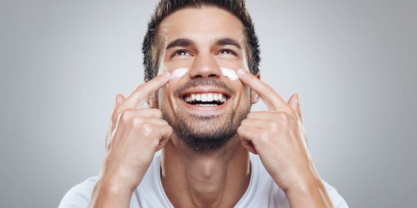 Skincare Men model applying moisturizer on face