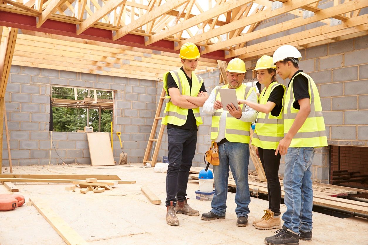 A construction team meet to review plan on the project's jobsite.