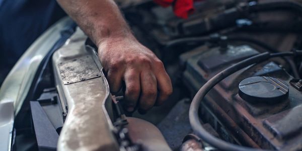 auto tech removing radiator cap before high quality repairs