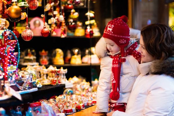 Child and mother enjoying festive holiday decorations.