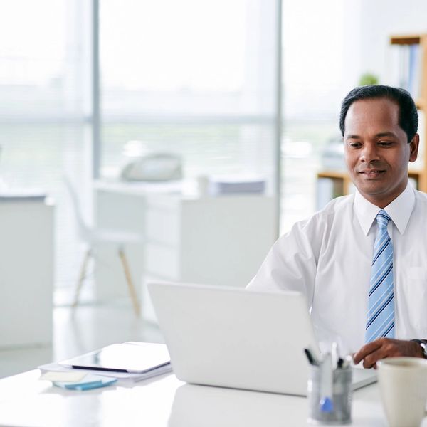 Two businessmen working together on a laptop.