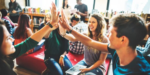 Enthusiastic group high-fiving in a book club discussion with Cultivated Mental Health