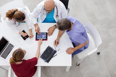 Medical team reviewing brain scans together in a collaborative meeting.