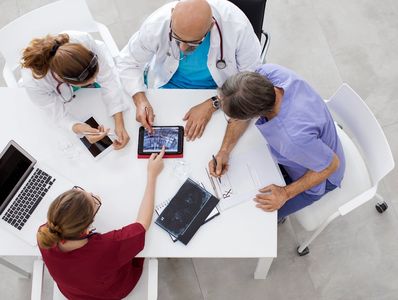 Doctors reviewing medical images and notes together at a table.