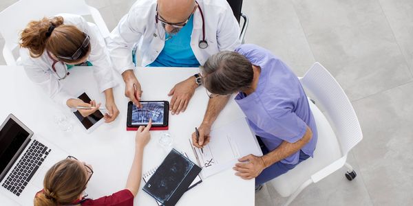 Doctors reviewing medical images and notes during a team meeting.