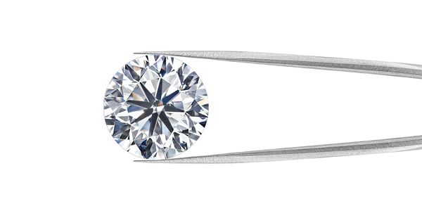 Round brilliant cut diamond being held in tongues
