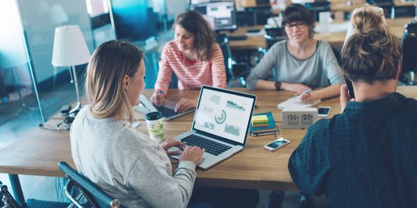 Multiple people are sitting at a table for a working meeting.