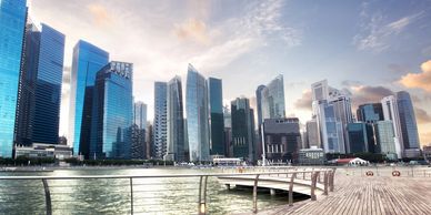 Singapore city skyline as the sun is setting with a boardwalk and the water in the foreground