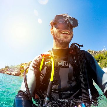 a scuba diver in turquoise water in front of Key West with a blue sky
