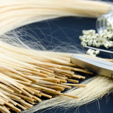 Close-up of blonde hair extensions being prepared.