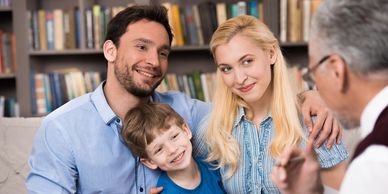 A happy family with a young boy talking to a professional.