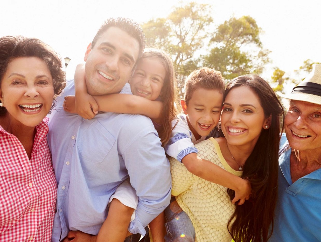 Happy multi-generational family enjoying time outdoors on a sunny day.