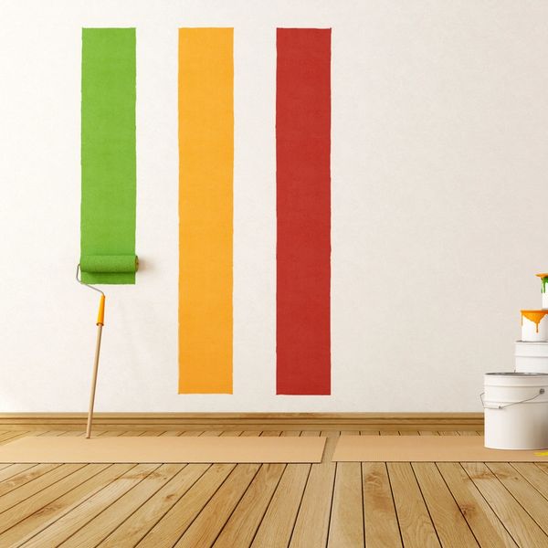 Three vertical paint stripes on a wall in green, yellow, and red.