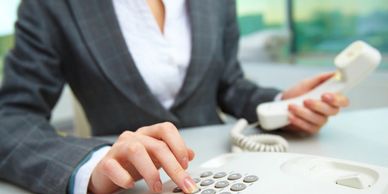 woman in gray business suit dialing a telephone