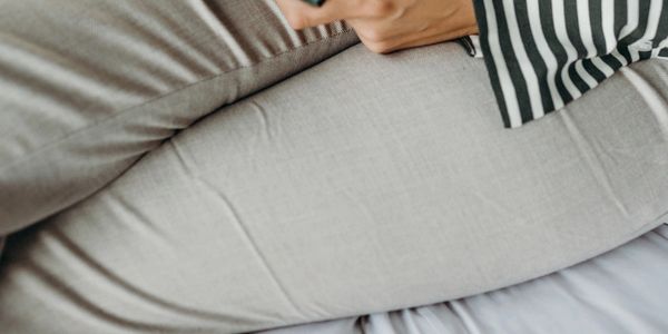 A person writing on a notepad with a pen.
