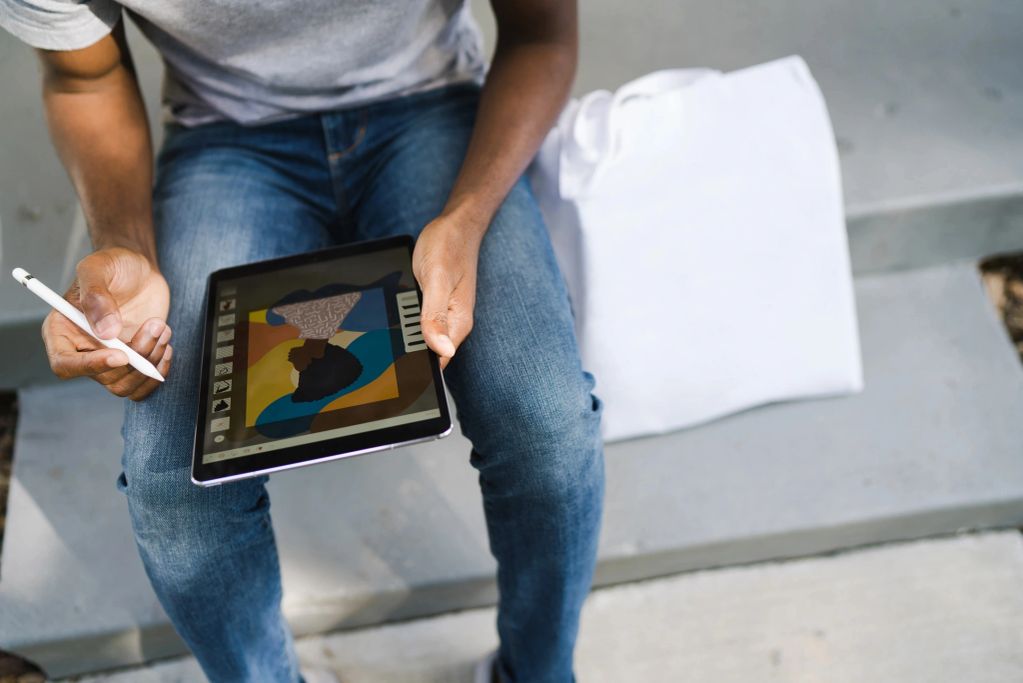 Person using a stylus to create digital art on a tablet.