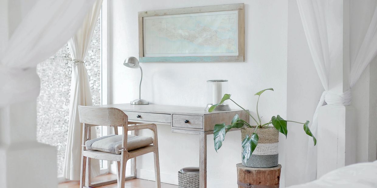 Minimalist workspace with natural wood furniture and a potted plant.