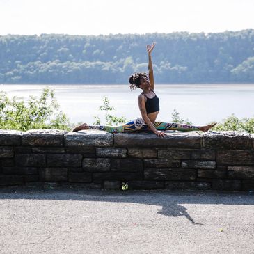 woman doing yoga splits on a low wall