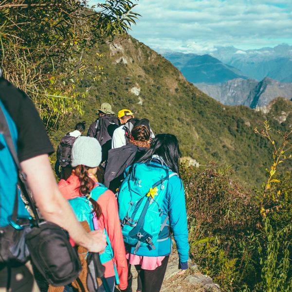 Group of hikers trekking on a mountain trail with backpacks.