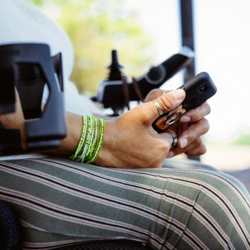 Person holding a smartphone while seated.