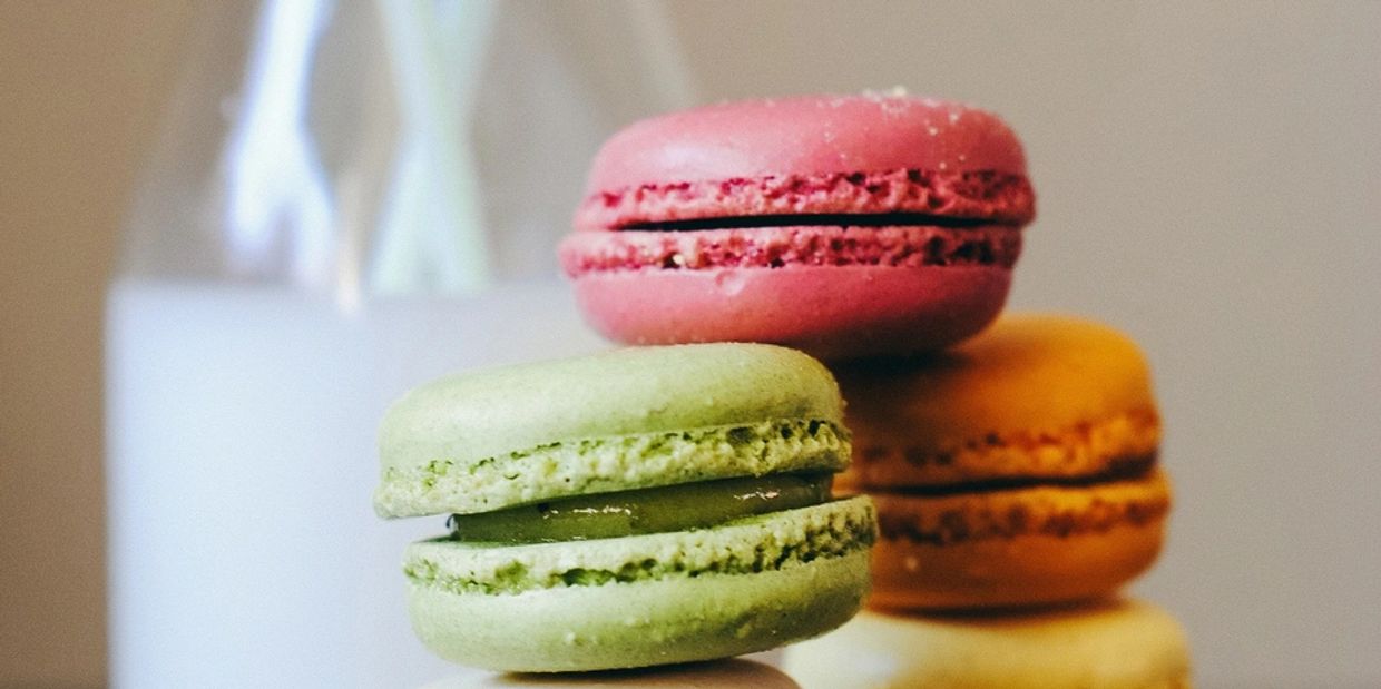 Close-up of colorful macarons stacked with a blurred background.