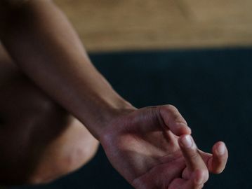 Close-up of a hand in a meditative yoga mudra pose.