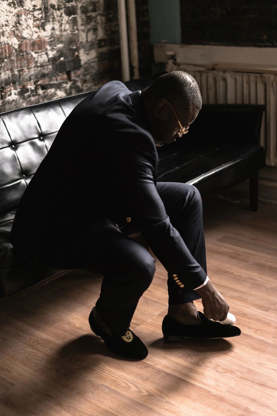 A man in a suit fixing his shoes